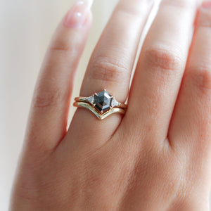 Hexagon Cut Black Diamond Ring with wave gold band on hand in sunlight