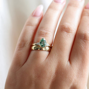 Pear cut green sapphire engagement ring with gold cigar band