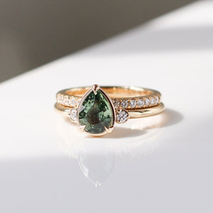 Pear cut green sapphire engagement ring with half eternity diamond band