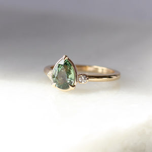 Pear cut green sapphire engagement ring quarter view