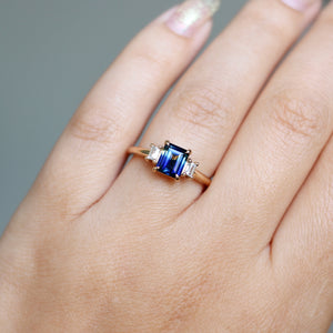 Emerald cut blue sapphire ring on hand